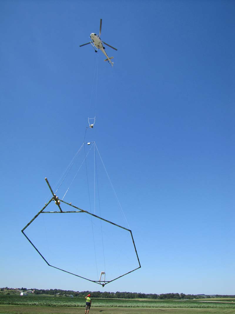 A hoop shaped geophysical device which contains sensors is suspended beneath a helicopter used to conduct surveys.