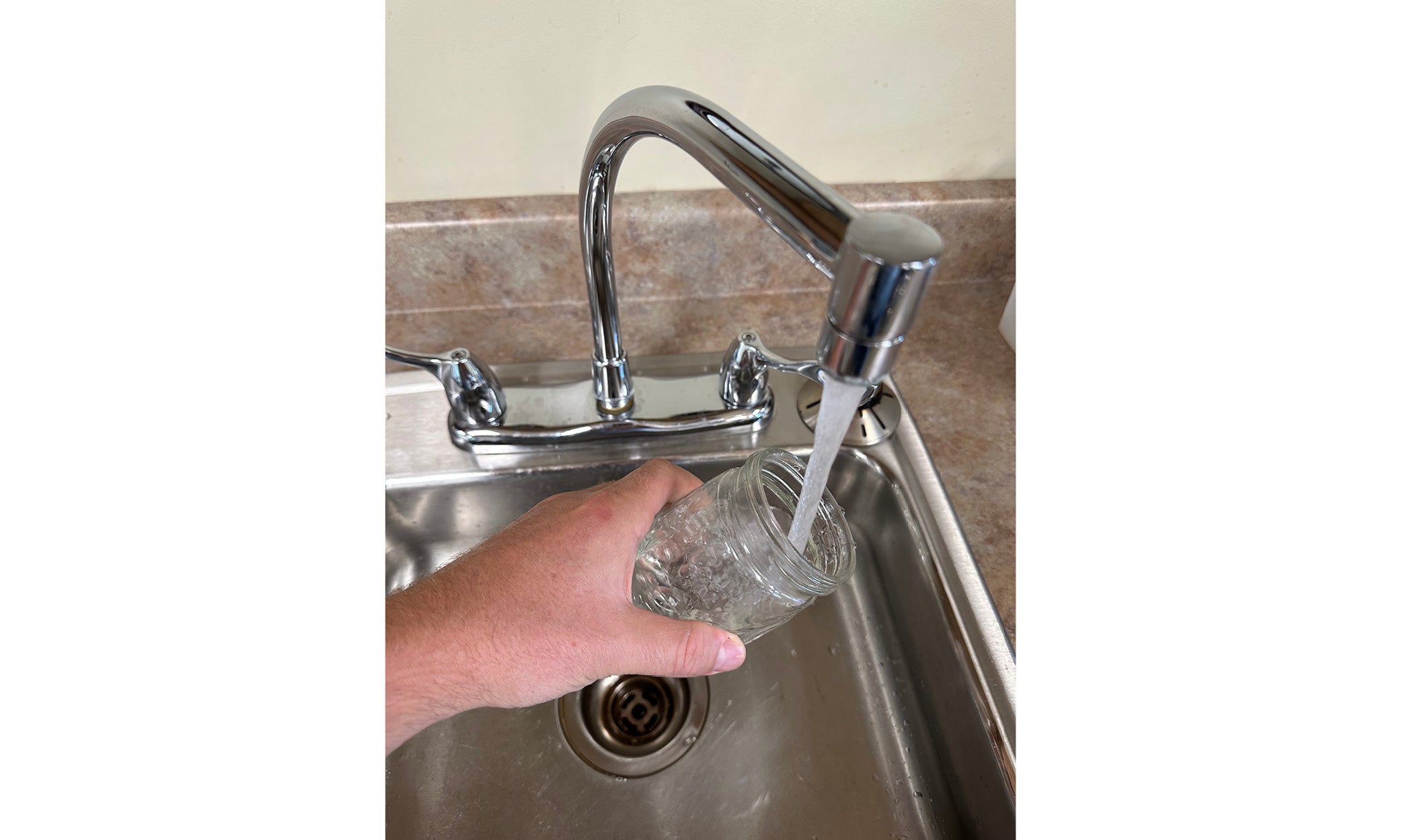 hand taking water sample